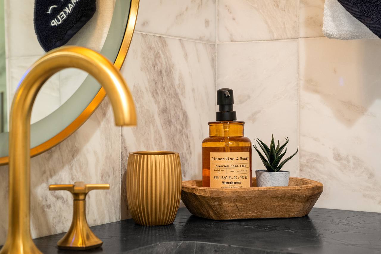 Bathroom detail — gold fixtures and Clementine & Honey hand soap