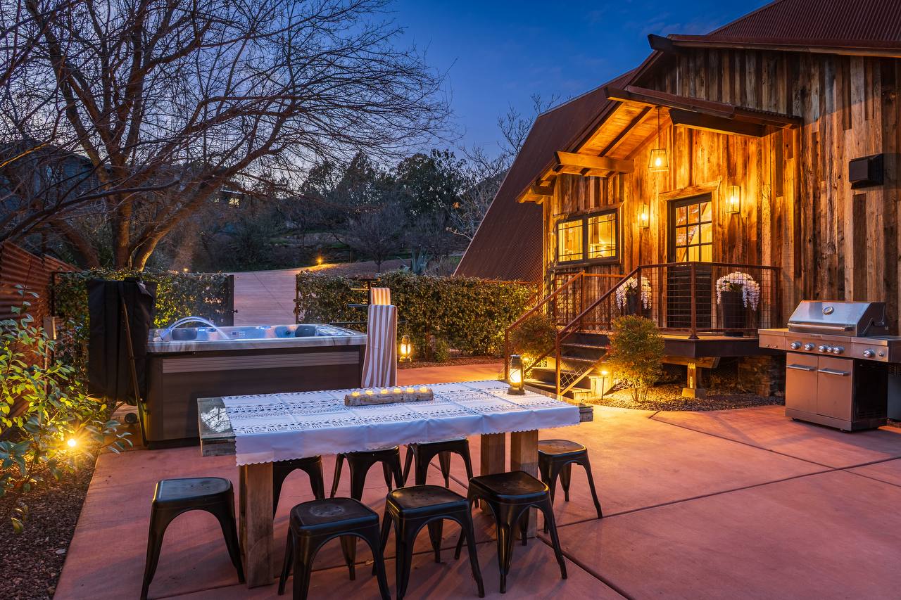 Outdoor dining, hot tub, and BBQ at blue hour